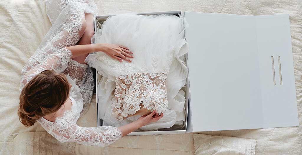 Bride opening her wedding gown preservation box after cleaning